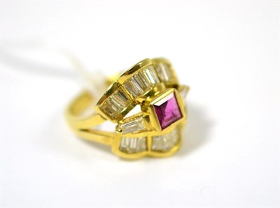 Lot 35 - A ruby and diamond ring, a square step cut ruby in a yellow rubbed over setting, with a tapered...
