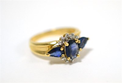 Lot 56 - A sapphire and diamond ring, an oval cut sapphire between two pear cut sapphires, with...