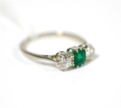 Lot 84 - An emerald and diamond three stone ring, an emerald-cut emerald between two old cut diamonds in...