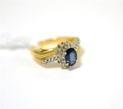 Lot 88 - A sapphire and diamond ring, an oval cut sapphire within a border of diamonds, to diamond set...