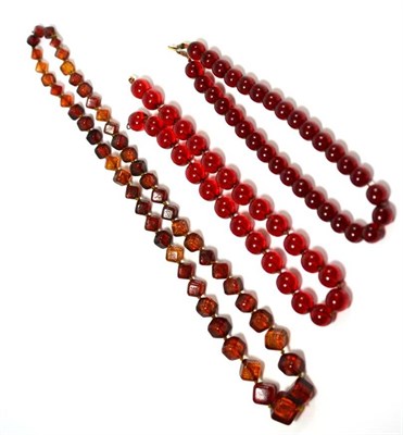 Lot 90 - A carved bead necklace, formed of graduated deep orange cube beads with carved floral...