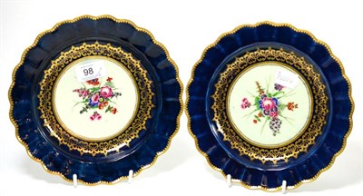 Lot 98 - A pair of First Period Worcester porcelain plates painted with flowers on a blue and gilt...