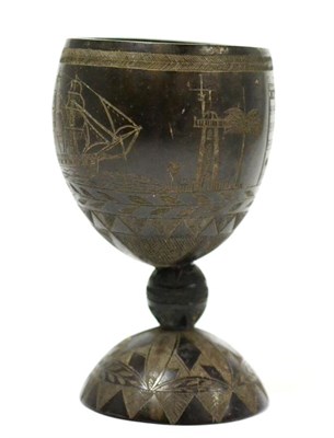 Lot 126 - A coconut cup carved with a sailing ship and buildings within geometric borders, 13.5cm high