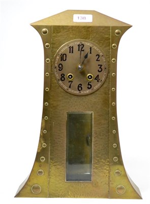 Lot 138 - An Arts & Crafts striking mantel clock, hammered brass front and a bevelled glass panel, 4-1/2-inch