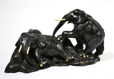 Lot 149 - An ebony and bone group of two elephants on a rocky moulded base, 38cm diameter