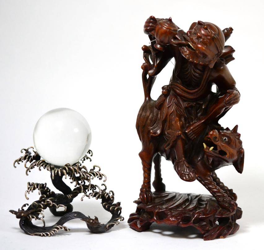 Lot 152 - Chinese root wood carving of a man sitting of mythical beast, 30cm high; and a crystal ball on...