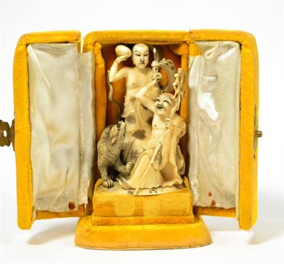 Lot 185 - A late 19th/early 20th century Chinese ivory group depicting two figures and a tiger, 10cm high...