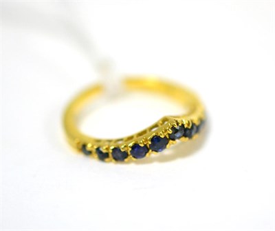 Lot 254 - A sapphire wishbone ring, with graduated round cut sapphires in yellow claw settings, on a...