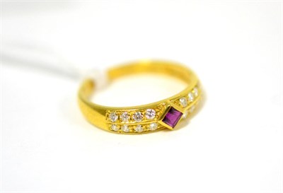 Lot 260 - A ruby and diamond ring, a square step cut ruby in yellow rubbed over setting, flanked by round...