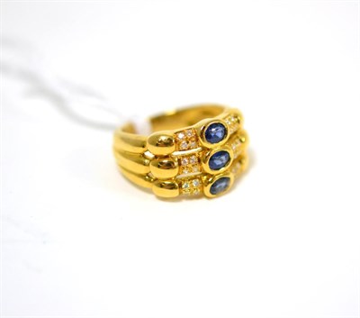 Lot 262 - A sapphire and diamond ring, formed of three bands, each with an oval cut sapphire in yellow rubbed