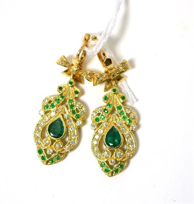 Lot 263 - A pair of emerald and diamond earrings, a round brilliant cut diamond set yellow bow suspends a...