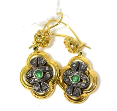 Lot 264 - A pair of emerald set earrings, a floral decorated stud suspends a yellow quatrefoil drop with...