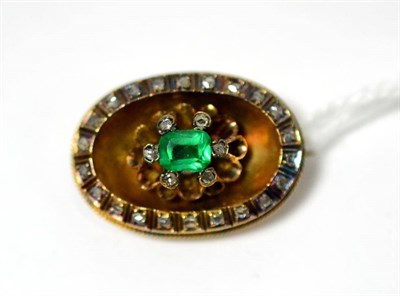 Lot 274 - An emerald and diamond brooch, an emerald-cut emerald in a rose cut diamond set claw setting,...