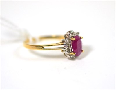 Lot 280 - A ruby and diamond cluster ring, an oval cut ruby in a yellow claw setting within a border of round