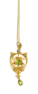 Lot 282 - A peridot and seed pearl pendant on chain, an oval cut peridot in milled yellow setting, within...
