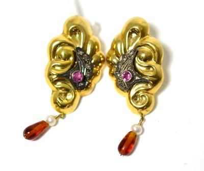 Lot 321 - A pair of earrings, the fancy yellow scroll drops inset with a round cut ruby within a white...