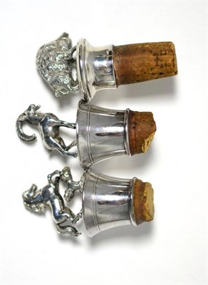 Lot 329 - ^A pair of silver bottle stoppers with pony/goat finials and another