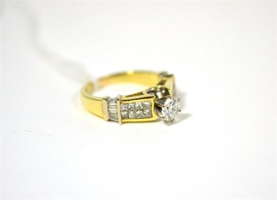 Lot 425 - A diamond ring, a round brilliant cut diamond in a yellow claw setting above shoulders tension...