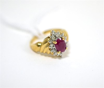 Lot 429 - A ruby ring, an oval cut ruby in a yellow claw setting within a border of round brilliant cut...