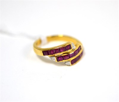 Lot 434 - A ruby and diamond three row ring, set with calibré cut rubies in yellow channel settings,...