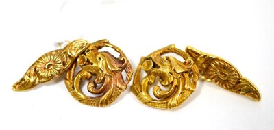 Lot 455 - A pair of cufflinks, the round heads formed of a dragon's head within a scroll frame, chain...