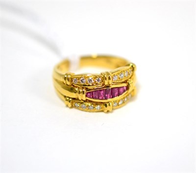 Lot 461 - A ruby and diamond ring, with a central band of calibré cut rubies in yellow channel settings...