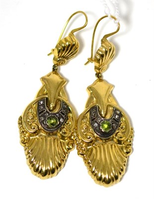 Lot 471 - A pair of peridot and diamond earrings, a yellow shell drop suspends a fancy yellow pendant...