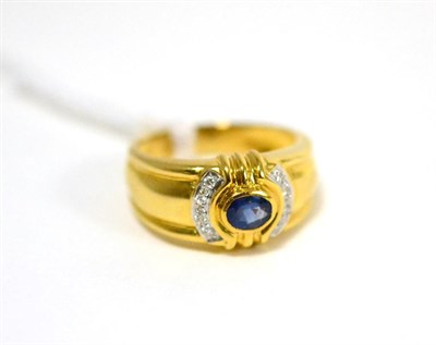 Lot 476 - A sapphire and diamond ring, the oval cut sapphire in a yellow rubbed over setting, with...