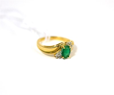 Lot 479 - An emerald and diamond ring, an oval cut emerald in yellow claw settings flanked by clusters of...