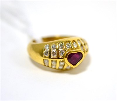 Lot 486 - A ruby and diamond ring, a heart cut ruby in a yellow rubbed over setting, within a border of round