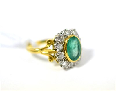 Lot 498 - An emerald and diamond cluster ring, the oval cut emerald in a yellow rubbed over setting...