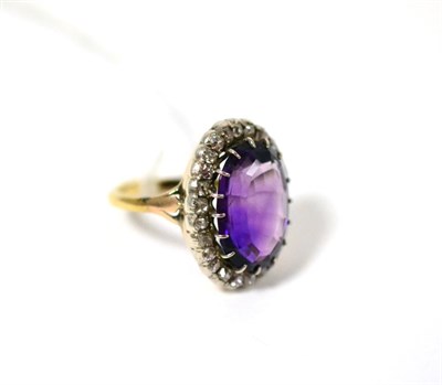 Lot 501 - An amethyst and diamond ring, the oval mixed cut amethyst in a white claw setting, within a...