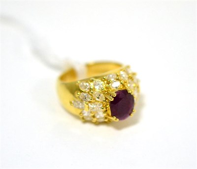 Lot 502 - A ruby and diamond cluster ring, an oval cut ruby in a yellow claw setting within a border of...