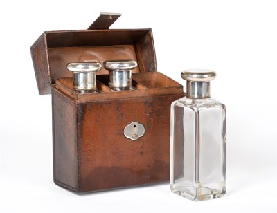 Lot 548 - Three glass silver topped jars in leather case, stamped Finnigans, London and a similar set