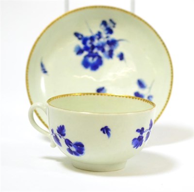 Lot 558 - A First Period Worcester tea cup and saucer, Giles decorated in dry blue with flower sprays,...