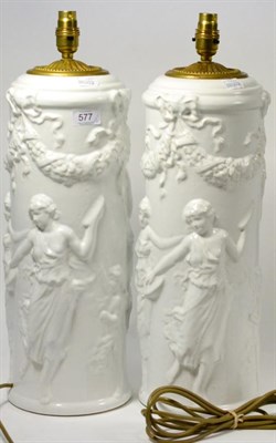 Lot 577 - A pair of Italian pottery lamp bases moulded with dancing classical figures, 53cm high