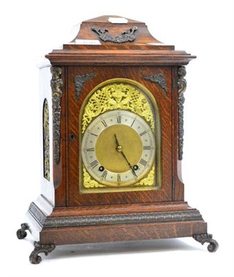 Lot 620 - An oak striking table clock, circa 1900, inverted bell top, side frets, arched brass dial, twin...