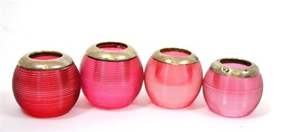 Lot 629 - Four cranberry composite glass match strikes and holders of ribbed circular form with silver...