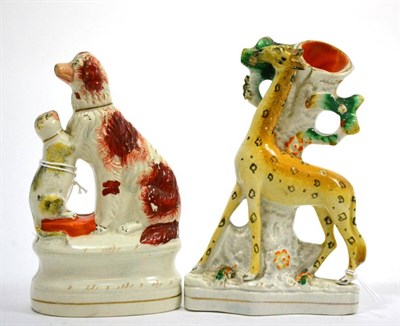 Lot 670 - A Staffordshire pottery spill vase, 19th century, modelled as a giraffe standing before a tree on a