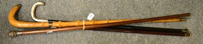 Lot 735 - An early 20th century walking cane with 9ct gold handle; another, with white metal double mask...