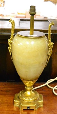 Lot 807 - A gilt metal mounted onyx lamp base, in Regency style, of ovoid form with loop and mask handles...