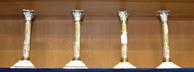 Lot 831 - Two pairs of silver candlesticks with stop fluted columns and loaded bases, height 26cm