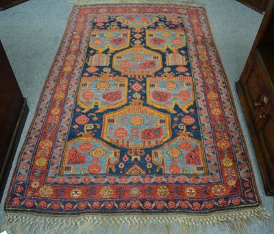 Lot 1210 - A Bidjar rug, Persian Kurdistan, The indigo field with heraldic motif enclosed by triple...