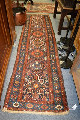 Lot 1220 - A narrow Karajah runner, Persian Azerbaijan, the indigo field with a column of polychrome...