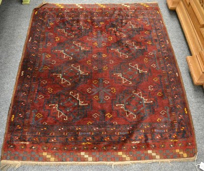 Lot 1223 - A Turkmen rug, North Afghanistan, The deep burgundy field with two columns of quartered güls...