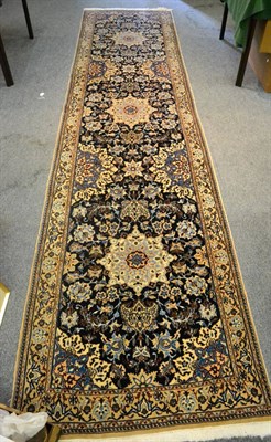 Lot 1245 - A narrow Isfahan runner, Central Persia, The deep indigo field with three flowerhead medallions...