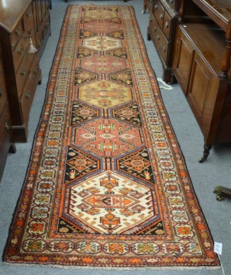 Lot 1251 - A North West Persian runner, the field with seven polychrome hexagons enclosed by ivory borders...