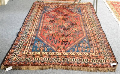 Lot 1254 - A Luri rug, West Iran, the coral pink lozenge field of tribal motifs enclosed by pale indigo...