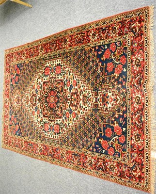 Lot 1259 - A Bakhtiari rug, West Persia, the indigo field of polychrome flowers around a stepped cream...