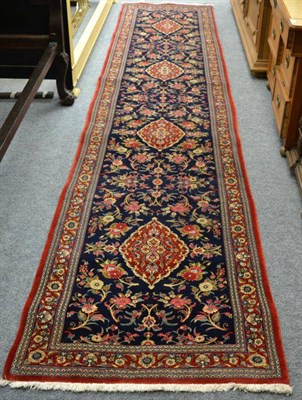 Lot 1265 - A Ghom narrow runner, Central Persia, The mid indigo field with naturalistic flowers centred by...